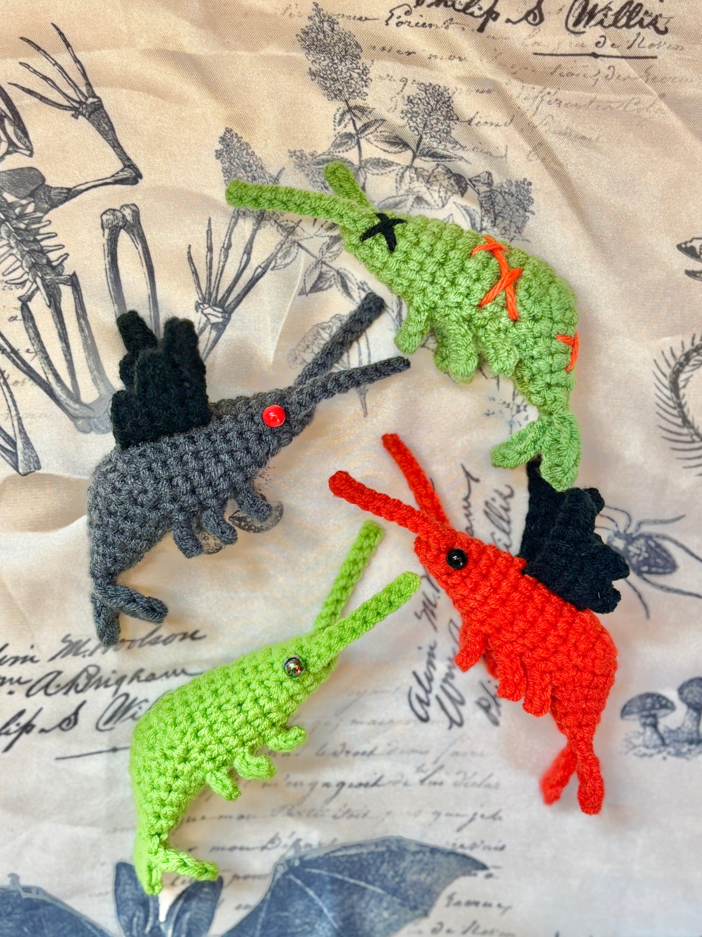 four monster themed shrimp against a halloween background