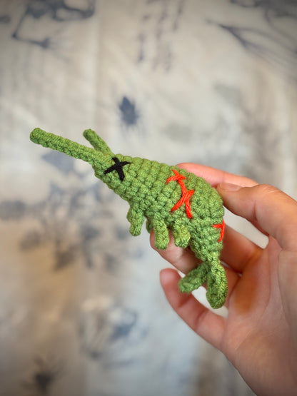 hand holding a green zombie shrimp with red stitches 